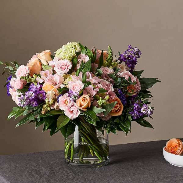 Mixed pink and purple flower bouquet in a glass vase