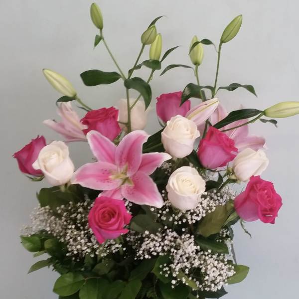 Pink lilies and roses in a clear glass vase