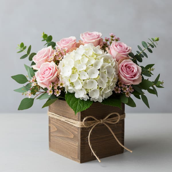 Pink roses and white hydrangea in a wooden box