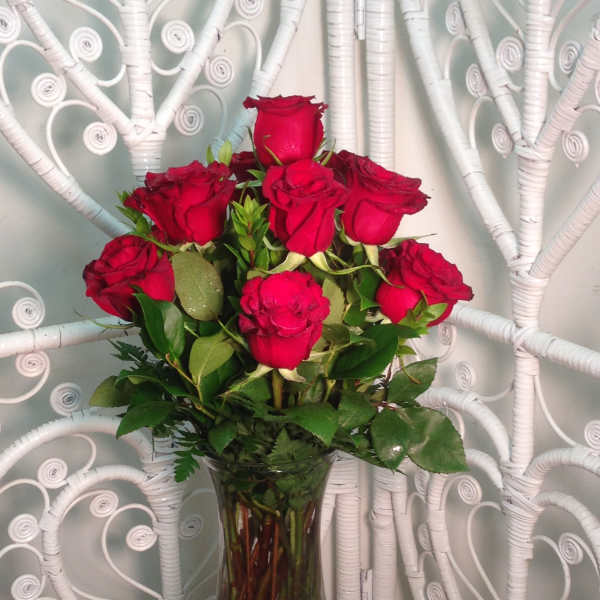 Red roses arranged in a clear glass vase