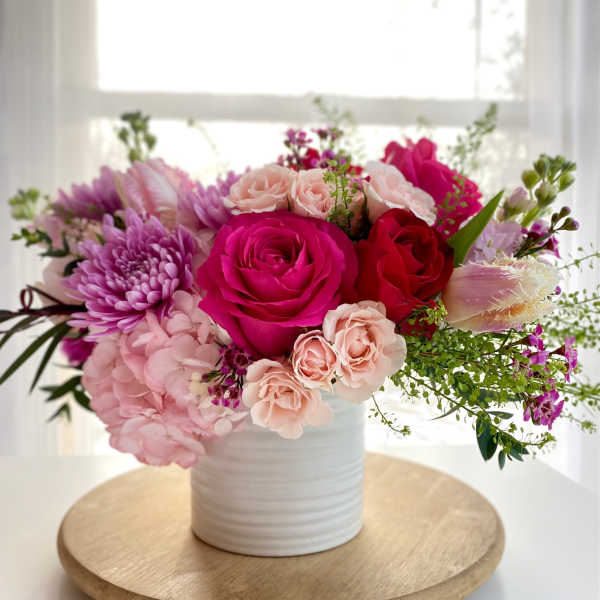 Pink and red roses with hydrangea in a white vase