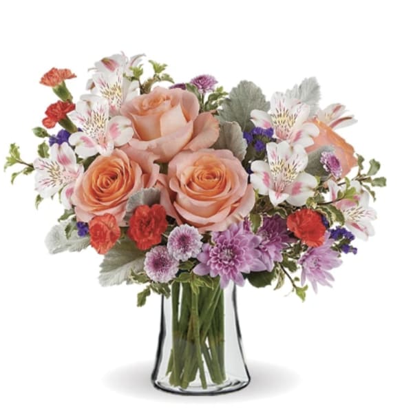 Bouquet of peach roses, alstroemeria, and purple flowers in a clear glass vase