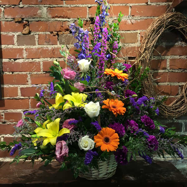 Colorful mixed flower arrangement in a wicker basket