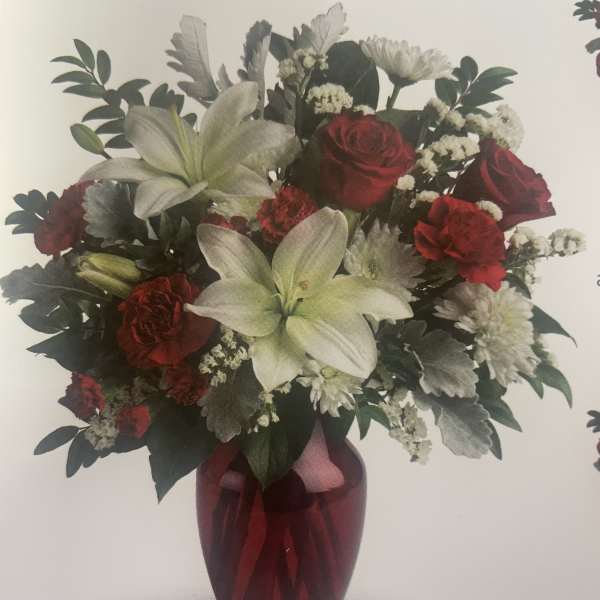Bouquet of red roses and white lilies in a red vase