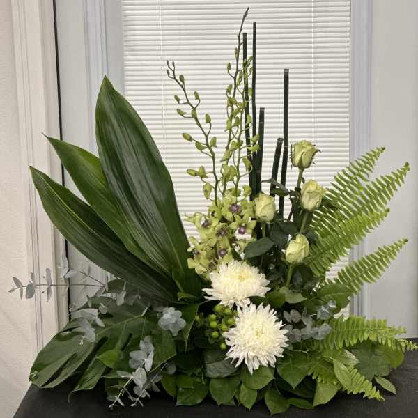 Green floral arrangement with white blooms and tall stems
