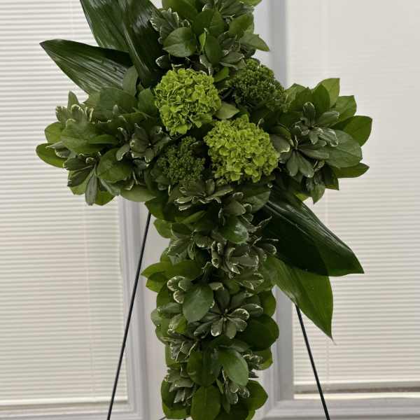 Green floral cross on a black stand
