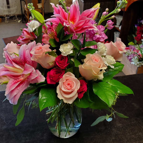 Mixed bouquet of pink lilies and roses in a glass vase