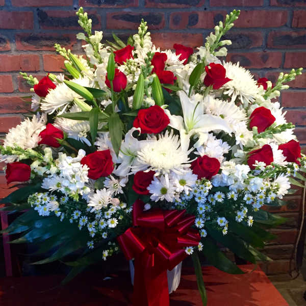 Large bouquet of red roses and white lilies with a red ribbon