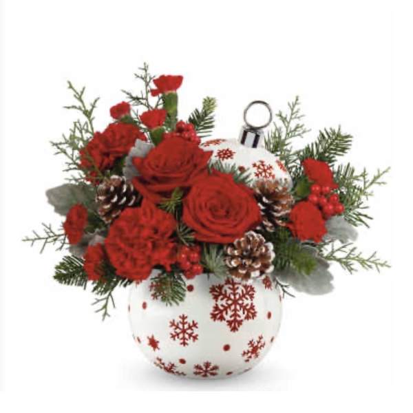 Red roses and carnations in a white ornament vase with pinecones