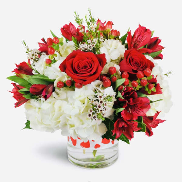 Red roses and white hydrangeas in a clear glass vase