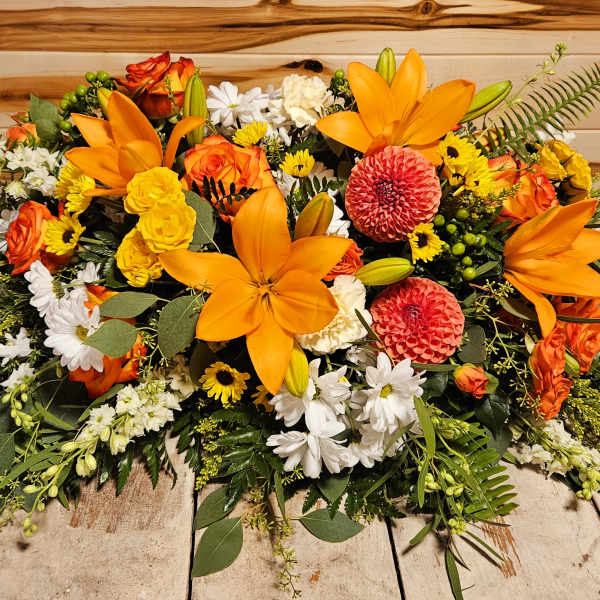 Large orange, yellow, and white floral arrangement on a table