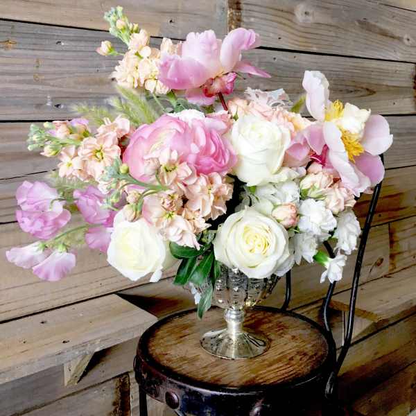 Pastel bouquet of pink and white flowers in a silver vase