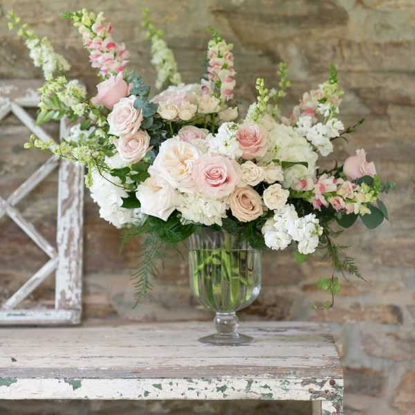 Blush and white rose arrangement in a clear glass vase