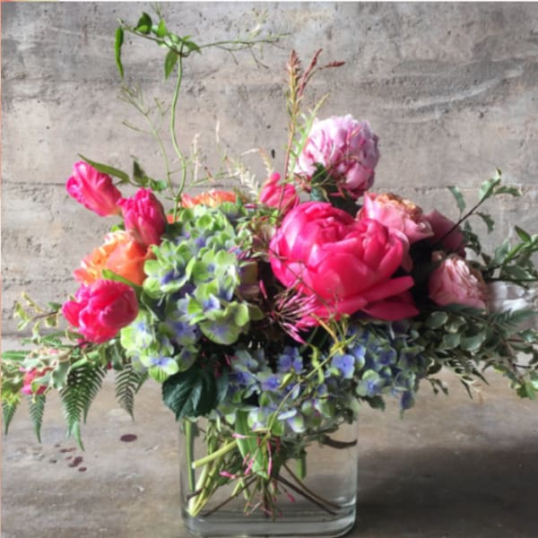 Mixed pink and purple floral arrangement in a clear glass vase