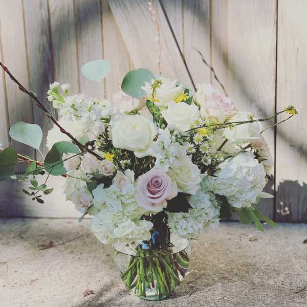 Bouquet of white and pale pink roses in a clear glass vase