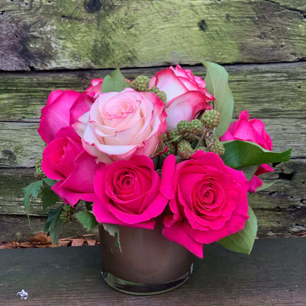 Pink and white roses arranged in a small glass vase