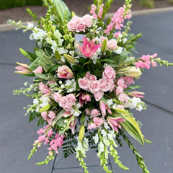 Large pink and white floral standing spray on an easel