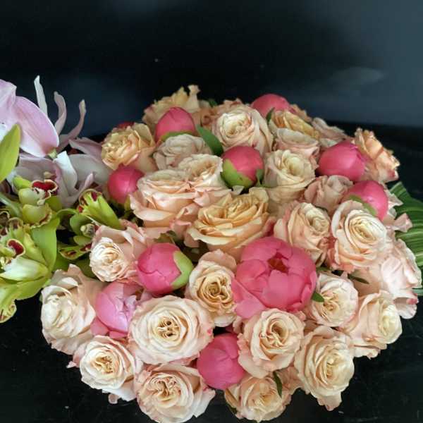 Bouquet of peach roses and pink peonies with green orchids