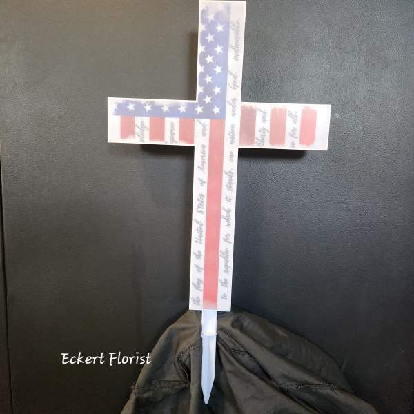American flag cross-shaped memorial stake with a white base
