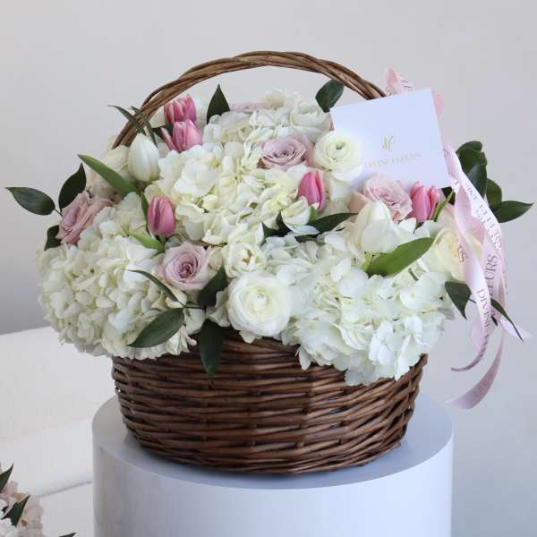 Basket of white and pink flowers with a ribbon and card