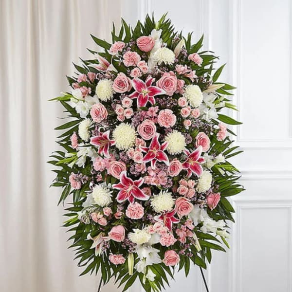 Standing floral spray with pink and white flowers on a black easel