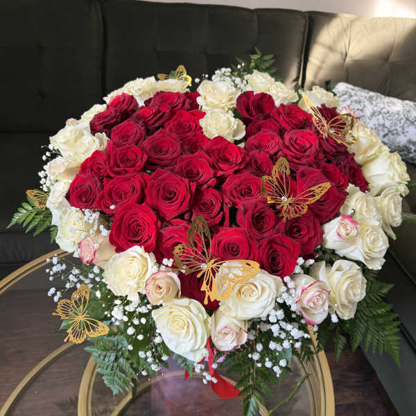 Heart-shaped bouquet of red and white roses with butterfly picks