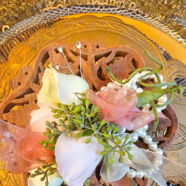 White rose corsage with pink ribbon and pearl accents