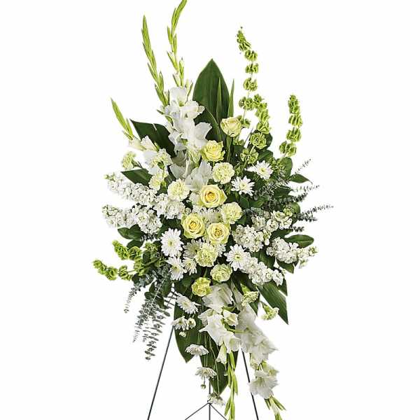 Tall white and pale yellow funeral spray on a stand