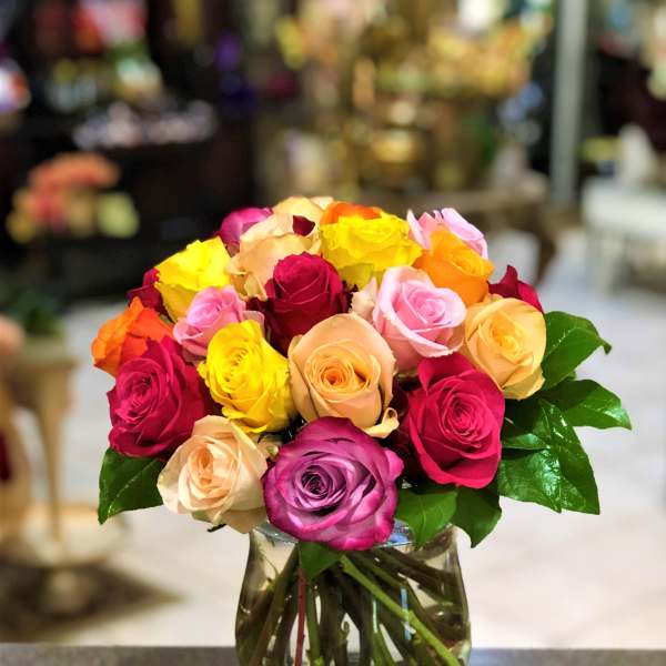 Bouquet of multicolored roses in a clear glass vase
