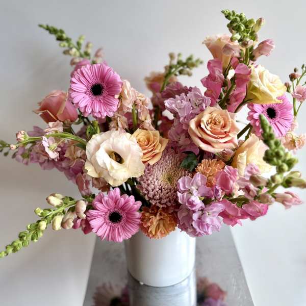 Pink and peach mixed bouquet in a white vase