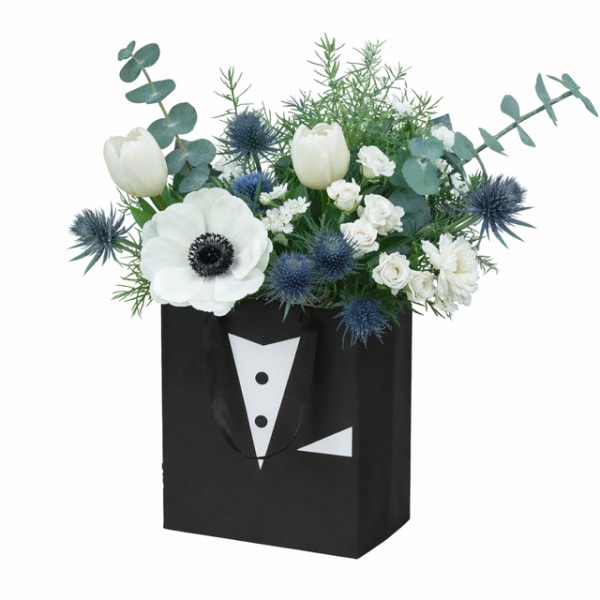 White flowers in a black gift bag with tuxedo print