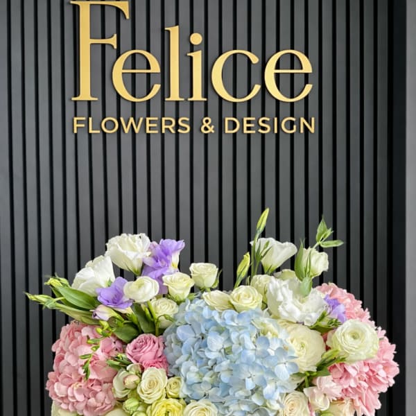 Pastel flower arrangement in a white hat box with hydrangeas and roses