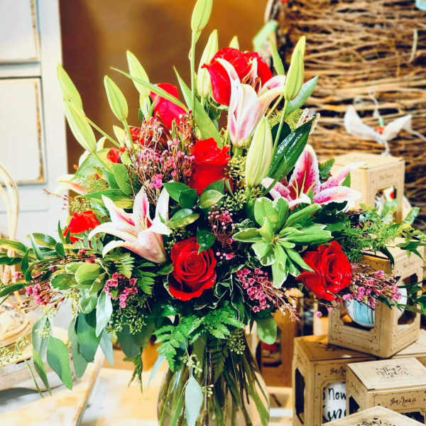 Bouquet of red roses and pink lilies in a glass vase