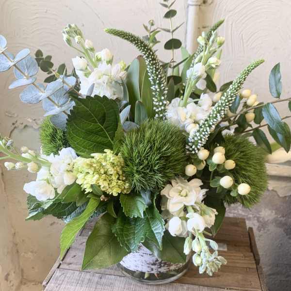 White and green floral arrangement in a glass vase
