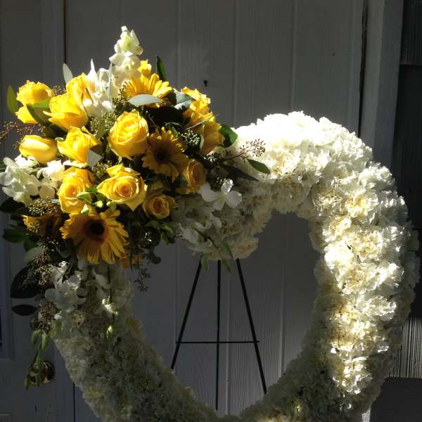 Heart-shaped floral wreath with yellow roses and white flowers