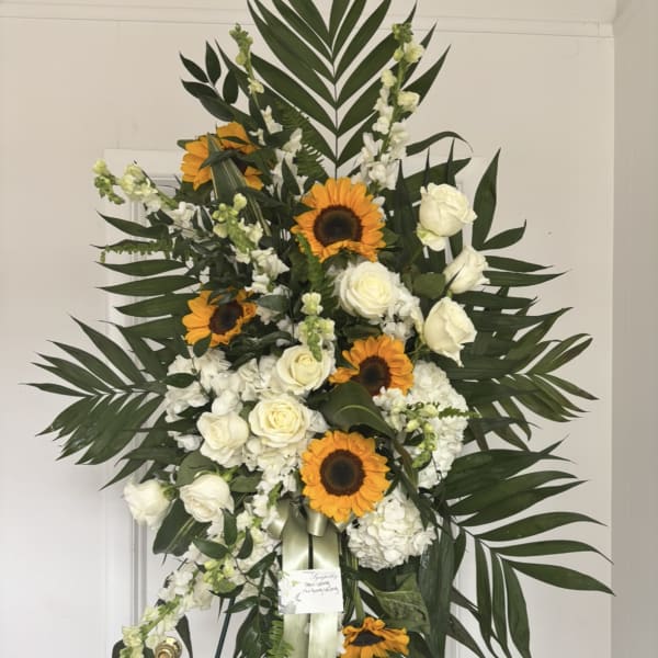 Standing floral spray with sunflowers and white roses on an easel