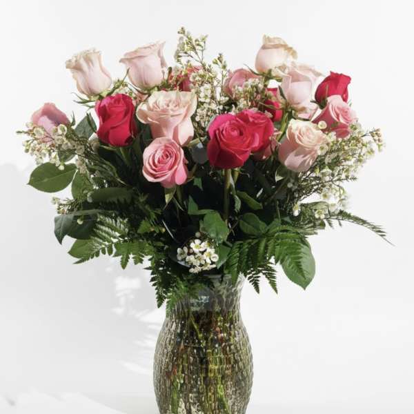 Pink and red roses arranged in a glass vase