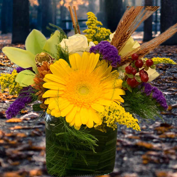 Yellow gerbera bouquet in a glass vase with purple accents