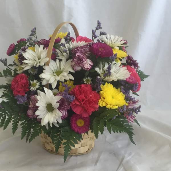 Mixed bouquet of daisies, carnations, and chrysanthemums in a basket