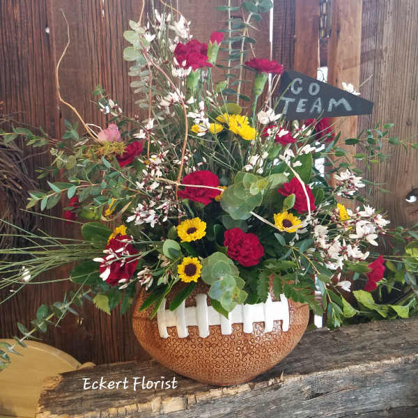 Mixed bouquet in a football-shaped vase with a "Go Team" sign