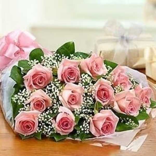 Bouquet of pink roses with baby's breath wrapped in pink and white paper