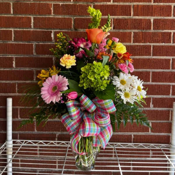 Mixed bouquet in a glass vase with a plaid bow