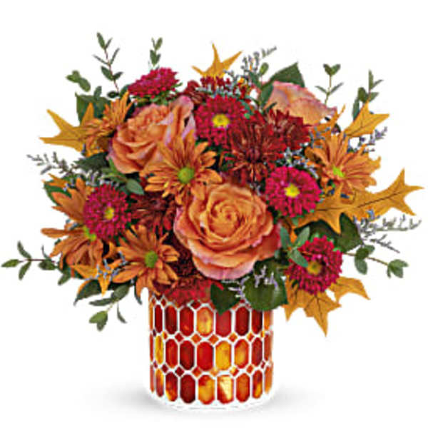 Orange and pink floral arrangement in a patterned vase