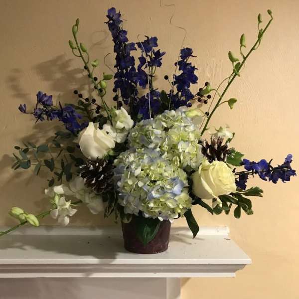 Blue and white floral arrangement in a dark vase
