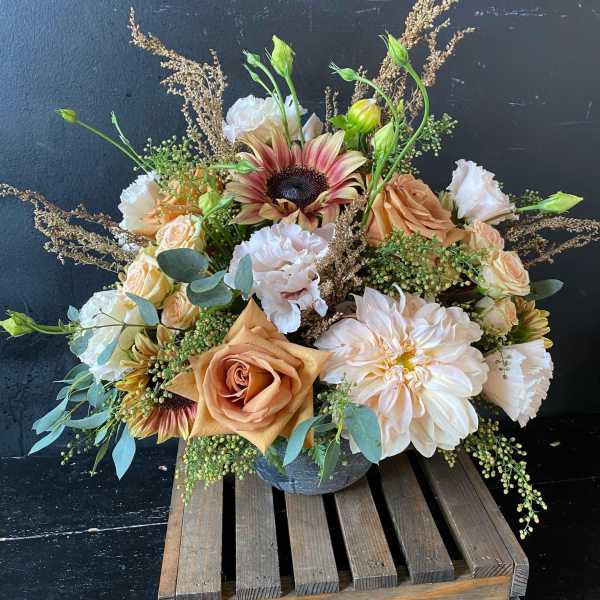 Peach and white floral arrangement in a gray vase