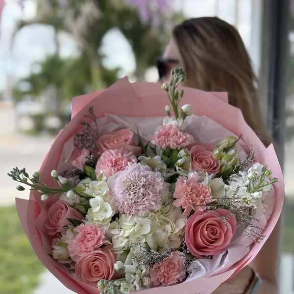 Pink rose and carnation bouquet wrapped in pink paper
