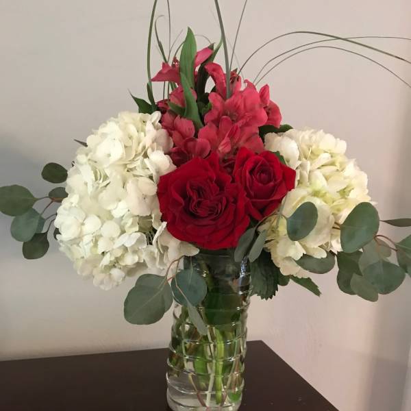 Red roses and white hydrangeas in a glass vase