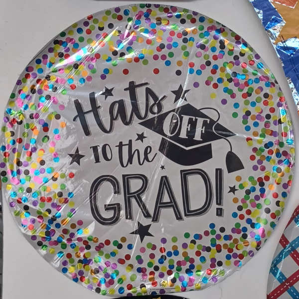 Round graduation balloon with confetti dots and "Hats Off to the Grad!" text