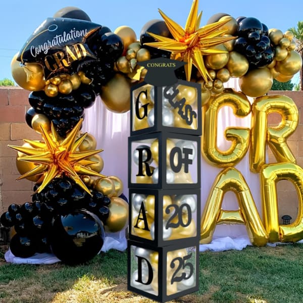Gold and black graduation balloon display with large GRAD letters