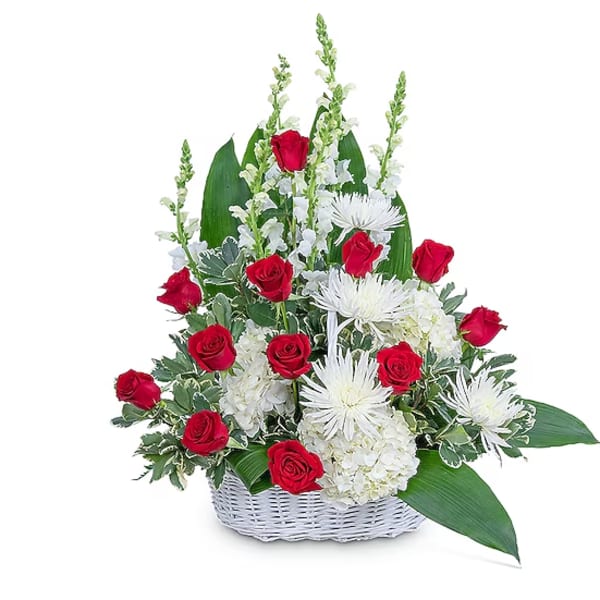 Red roses and white flowers in a white basket arrangement